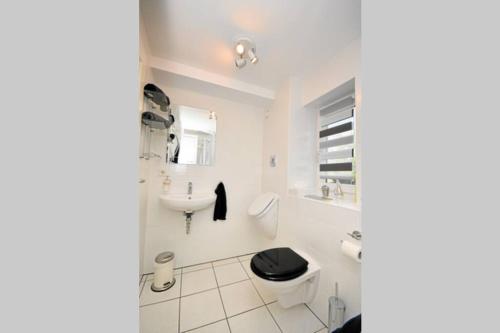 a white bathroom with a toilet and a sink at Ferienwohnung Gartenblick an der Mainschleife in Schwarzach am Main