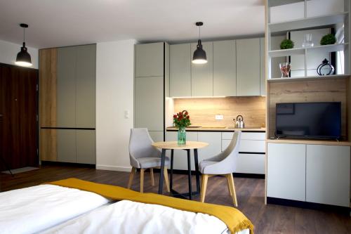 a bedroom with a bed and a kitchen with a table and chairs at Essence Apartments Sapphire in Poznań