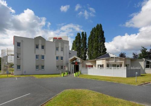 a large white building with a parking lot at Ibis Le Havre Sud Harfleur in Port de Harfleur
