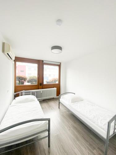 dwa łóżka w pokoju z dwoma oknami w obiekcie PF Unterkunft w mieście Pforzheim