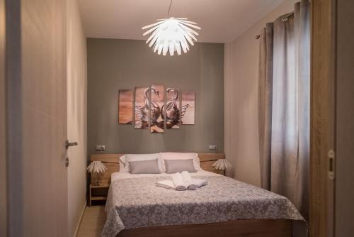 a bedroom with a bed and a chandelier at Haus Viktoria 2 in Limenas