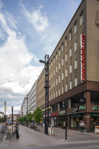 a building on a street with people walking past it at Omena Hotel Tampere in Tampere