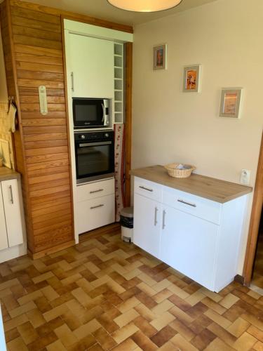 a kitchen with a stove and a microwave at maison blanche in Briançon