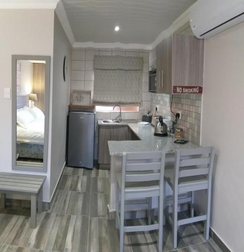 a kitchen with a table and chairs in a room at Schnehage Self Catering in Bloemfontein