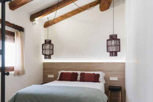 1 dormitorio con 1 cama y 2 lámparas de araña en Apartaments la rambla - Garnatxa - 4 persones en Cornudella