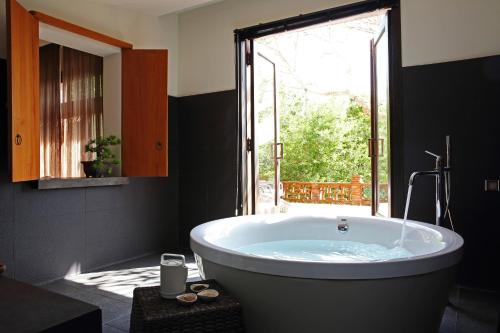 a large bath tub in a bathroom with a window at The One Nanyuan in Xinpu