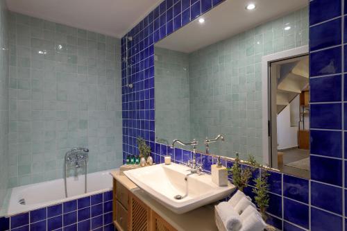 a blue tiled bathroom with a sink and a tub at Villa Mary's Holiday House in Pefki Rhodes