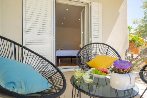 a patio with two chairs and a table with a bowl of fruit at Garden apartment in Pakoštane