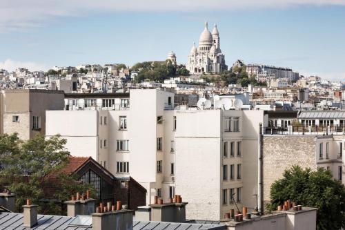 a view of the city from the roofs of buildings at Hotel Paradis in Paris