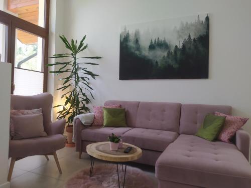 sala de estar con sofá púrpura y mesa en Między Wierchami, en Ponice