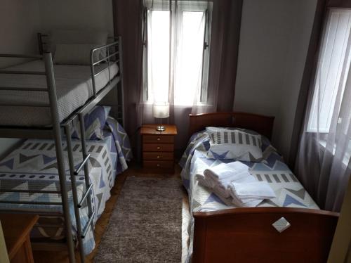 1 dormitorio con 2 literas y ventana en Casa da Ti Emília, en Cardigos