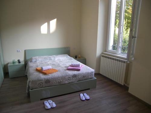 a bedroom with a bed with two slippers on the floor at Casa Molinari in Como