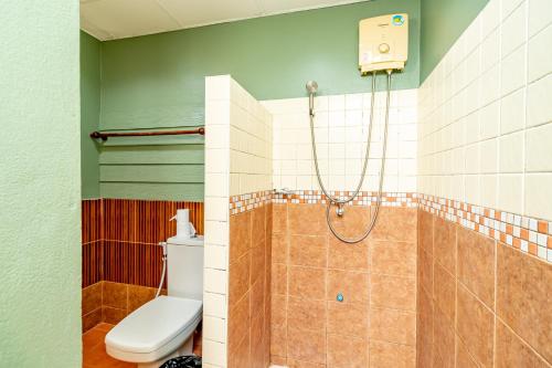 a bathroom with a toilet and a shower at The Palm Hotel in Salaya