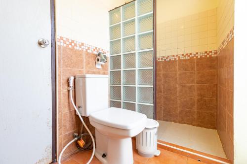 a bathroom with a toilet and a shower at The Palm Hotel in Salaya