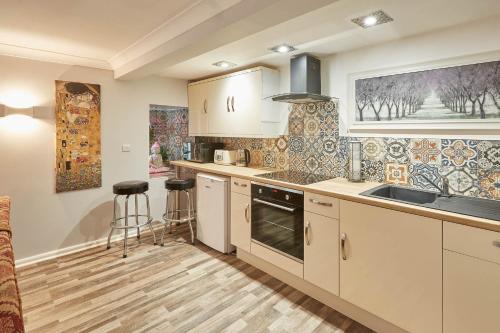 a kitchen with white cabinets and a sink at Host & Stay - In The Key Of Sea in Saltburn-by-the-Sea