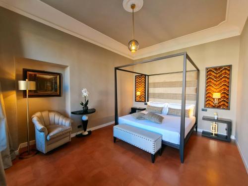 a bedroom with a canopy bed and a chair at Santa Maria Novella - WTB Hotels in Florence
