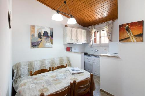 Amalia Cottages في آغيوس غوذيوس: مطبخ مع طاولة وكراسي ومطبخ مع طاولة ومطبخ