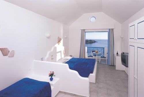 a bedroom with two beds and a view of the ocean at Lindia Thalassa in Pefki Rhodes