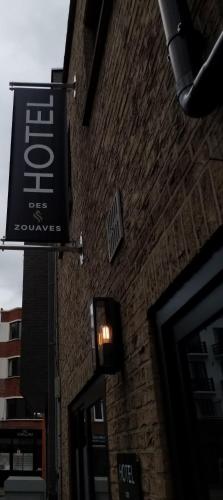 a sign on the side of a brick building at Hotel Des Zouaves in Koksijde