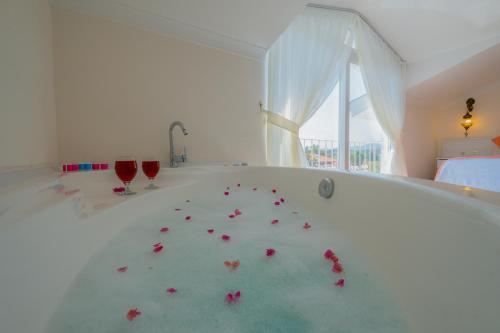 een kamer met 2 rode glazen en bloemen in een bad bij Infinity Beyaz Villa in Fethiye