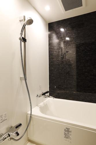 a shower in a bathroom with a bath tub at LOF HOTEL Shimbashi in Tokyo