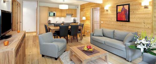 uma sala de estar com um sofá e uma sala de jantar em Large premium alpine apartment for 4 to 8 people em Vallorcine