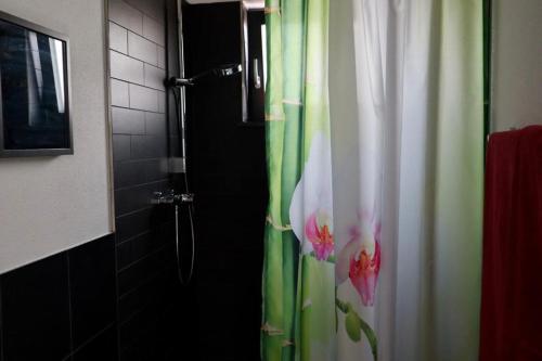 a shower curtain with flowers on it in a bathroom at Ambrahaus-Traumferienhaus in Altdorf