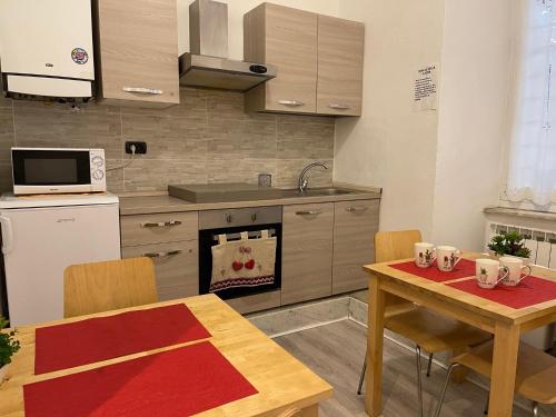 a kitchen with a wooden table and a kitchen with a table and chairs at Sapore di mare 5 Terre Affittacamere in La Spezia