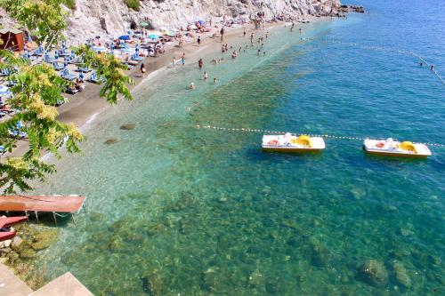 a beach with people and boats in the water at Cetara Costa d'Amalfi Residence in Cetara