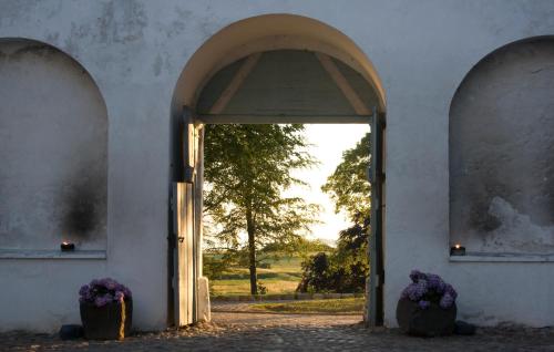 an open door to a white building with purple flowers at Dragsholm Slot in Hørve