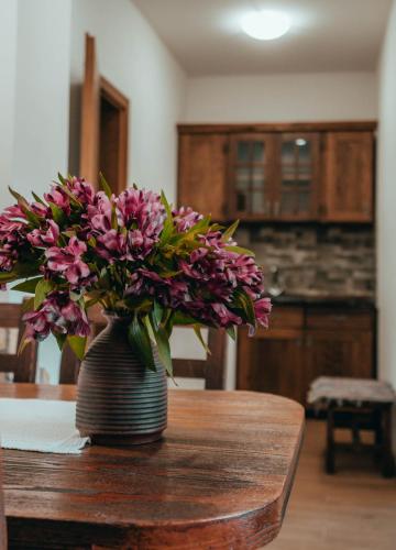 a vase of purple flowers sitting on a table at Etno Garden Apartments in Plitvička Jezera