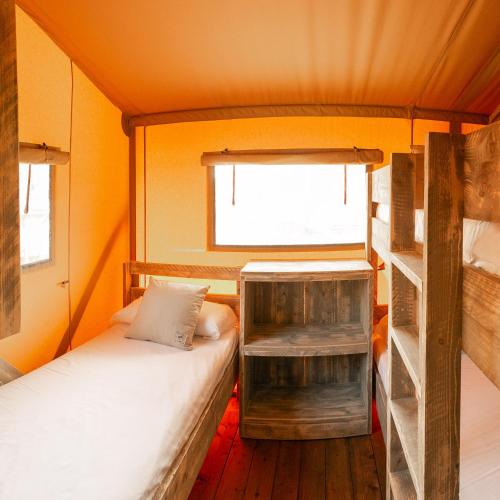 a small room with two bunk beds and a window at HolaCamp Sitges Garrofer in Sitges