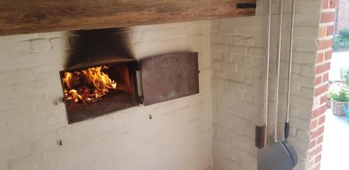 a brick oven with a fire in it at Huis van Silvie in Koolskamp