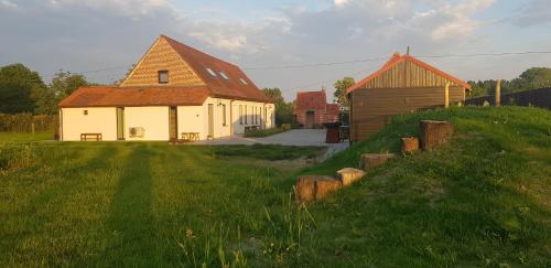 a house and a barn on a grass field at Huis van Silvie in Koolskamp