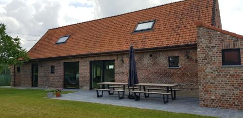 a brick building with a picnic table in front of it at Huis van Silvie in Koolskamp