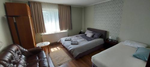 1 dormitorio pequeño con 1 cama y 1 sofá en Villa VértesKacsa, en Vértesacsa