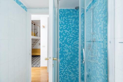 een badkamer met een glazen douche met blauwe tegels bij iFlat Yellow Monti Studio Apartment in Rome