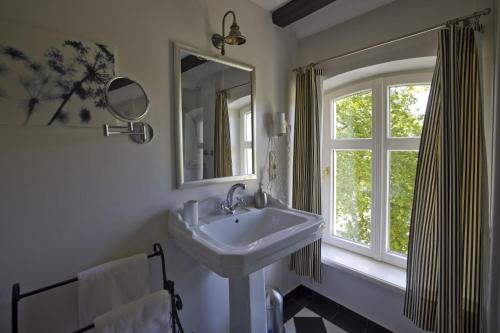 a bathroom with a sink and a window at Hotel Hochzeitshaus in Aurich