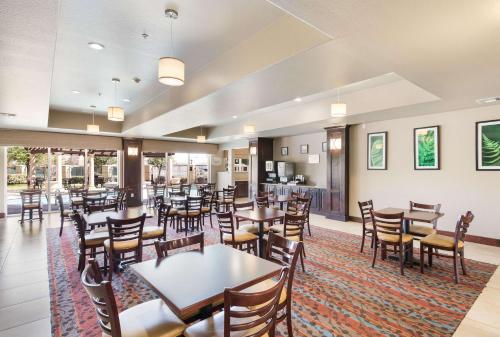 a restaurant with tables and chairs and a kitchen at Sleep Inn & Suites Midland West in Midland
