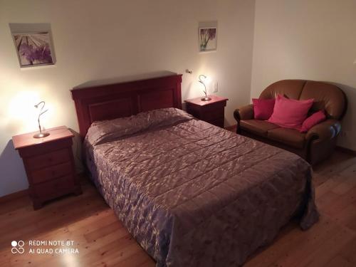 a bedroom with a bed and a couch and two lamps at Casas Vale Martinho in Santa Comba Dão
