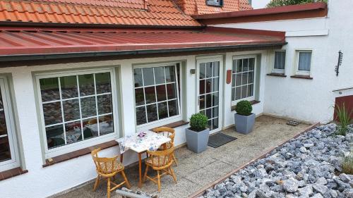 een patio met een tafel en stoelen op een huis bij Pension Backhaus in Waldeck