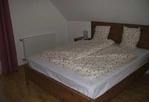 a bedroom with a large bed with white sheets and pillows at Ferienwohnung Hammerlhaus-Zirngast in Eibiswald