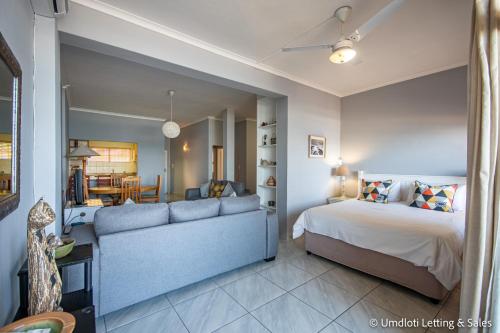 a bedroom with a bed and a couch at Wavecrest in Umdloti