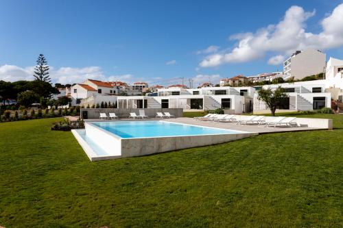 uma piscina num quintal com edifícios brancos em Ericeira Prime Villas em Ericeira