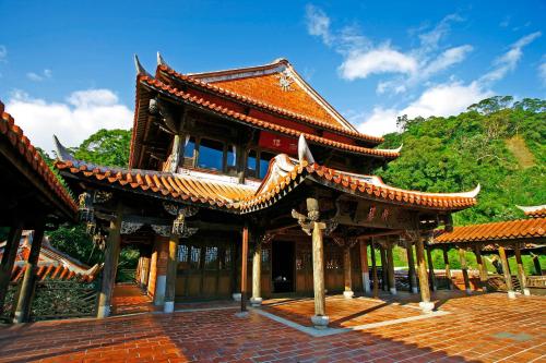 a building with a red roof with trees in the background at The One Nanyuan in Xinpu