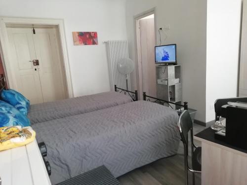 um quarto com uma cama e uma televisão em L'Angelo em Omegna