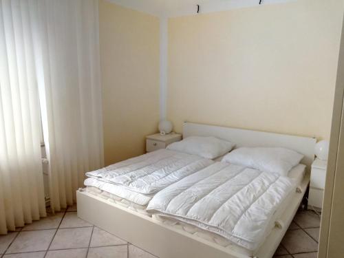 a bed with white sheets and pillows in a bedroom at Steinatal in Bad Sachsa