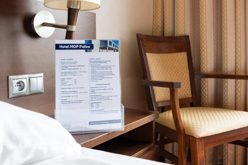 a room with a bed and a sign and a chair at Hotel Police in Police Mostowe
