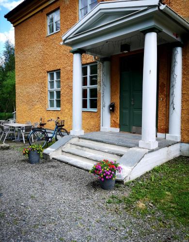 dom z zielonymi drzwiami i dwoma doniczkami kwiatów w obiekcie Åredalens fjällgård w mieście Järpen