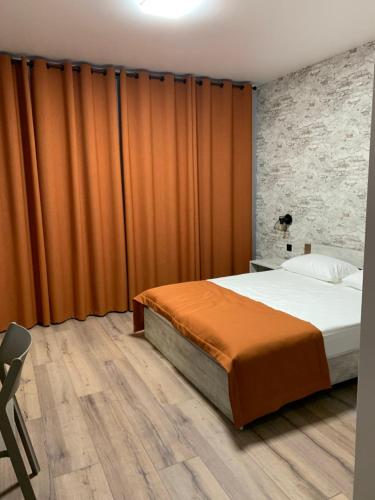 a bedroom with a bed and orange curtains at Fishel in Odesa
